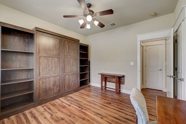 unfurnished office featuring visible vents, light wood finished floors, and a ceiling fan