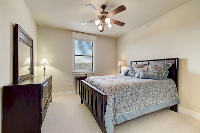 bedroom featuring light carpet, baseboards, and ceiling fan