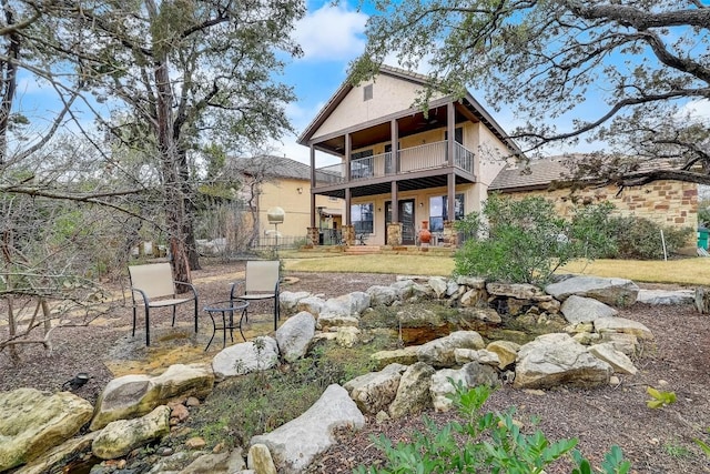 rear view of property featuring stucco siding and a balcony