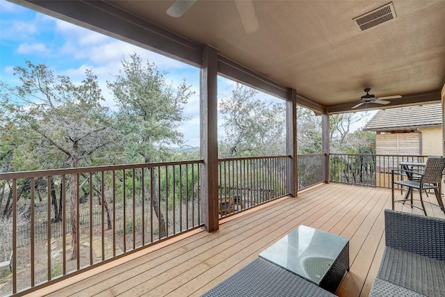 wooden terrace featuring ceiling fan and visible vents