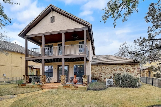 back of house featuring a fenced backyard, a balcony, and a yard
