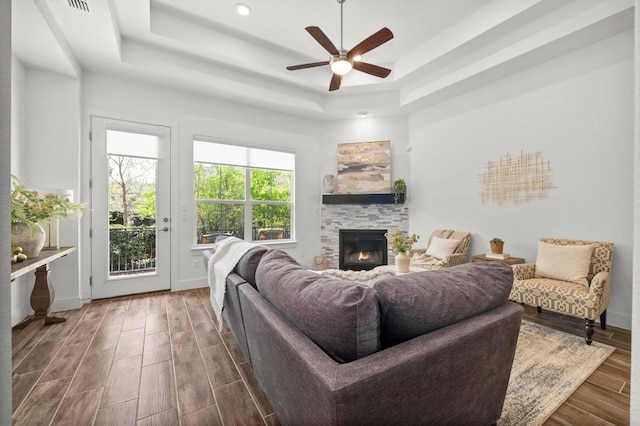 206 Olivia Dr Unit 120, Austin, TX 78738 - living room with a tray ceiling, a ceiling fan, a stone fireplace, wood finished floors, and recessed lighting