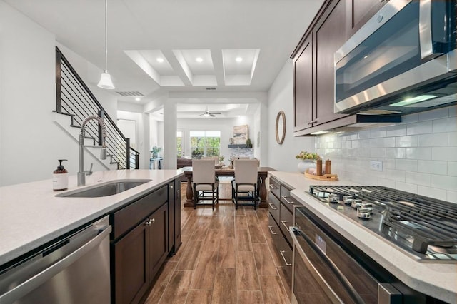 206 Olivia Dr Unit 120, Austin, TX 78738 - kitchen with appliances with stainless steel finishes, a sink, dark brown cabinets, light countertops, and recessed lighting