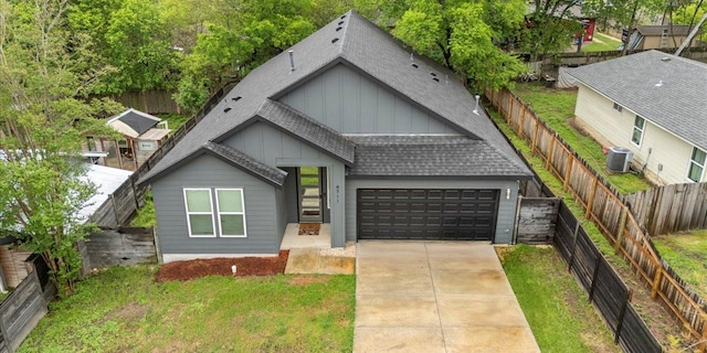4711 Little Hill Cir, Austin, TX 78725 - view of front of home with board and batten siding, a shingled roof, an attached garage, central AC, and concrete driveway