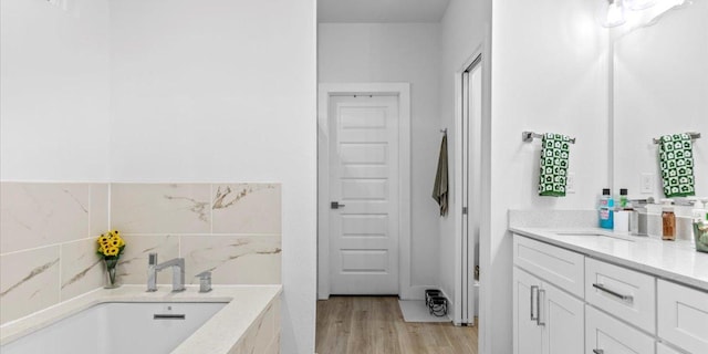 4711 Little Hill Cir, Austin, TX 78725 - full bath featuring vanity, a garden tub, and wood finished floors