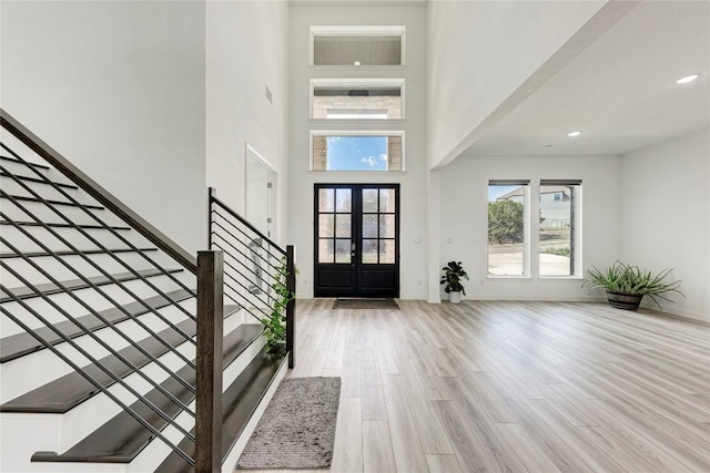 2420 Novara Trl, Leander, TX 78641 - entrance foyer with stairs, wood finished floors, a high ceiling, baseboards, and french doors