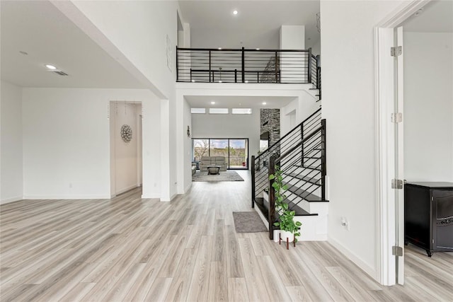 2420 Novara Trl, Leander, TX 78641 - foyer with wood finished floors, stairs, a towering ceiling, baseboards, and recessed lighting