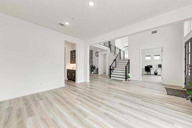 2420 Novara Trl, Leander, TX 78641 - unfurnished living room with stairs, light wood finished floors, recessed lighting, and an office area