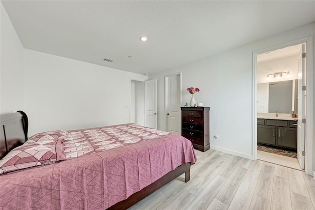 2420 Novara Trl, Leander, TX 78641 - bedroom featuring light wood finished floors, recessed lighting, and ensuite bathroom