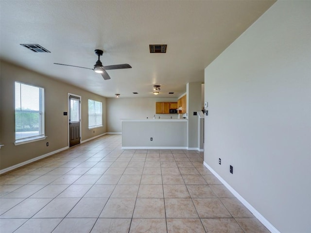 335 Dandelion Loop, Kyle, TX 78640 - unfurnished living room featuring ceiling fan and light tile patterned floors