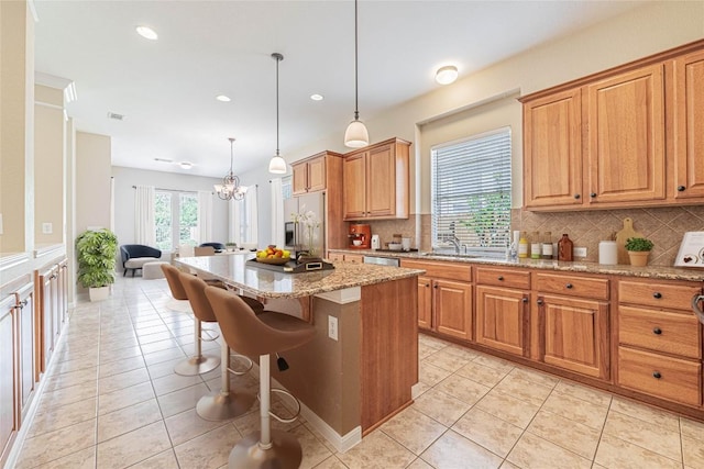 2009 Tillman Dr, Cedar Park, TX 78613 - kitchen featuring stainless steel appliances, decorative backsplash, light tile patterned flooring, a breakfast bar area, and light stone counters