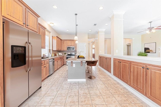 2009 Tillman Dr, Cedar Park, TX 78613 - kitchen featuring stainless steel appliances, a kitchen bar, ceiling fan, tasteful backsplash, and a kitchen island