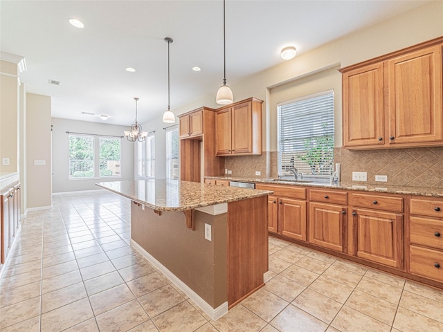 2009 Tillman Dr, Cedar Park, TX 78613 - kitchen featuring light tile patterned floors, decorative backsplash, a chandelier, light stone countertops, and a kitchen island