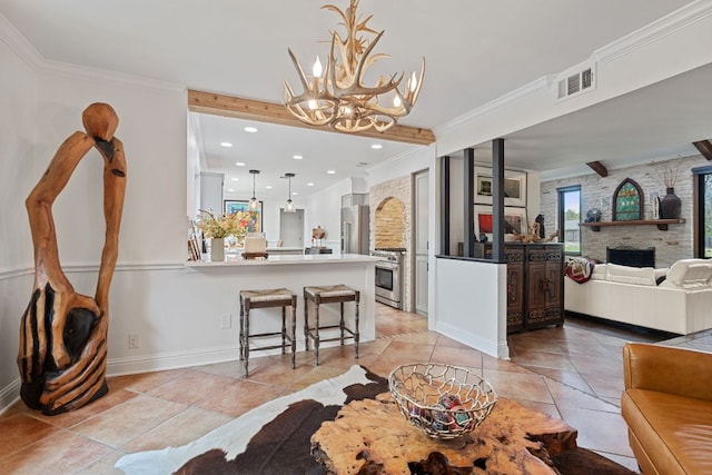 dining space featuring a chandelier, visible vents, a stone fireplace, and ornamental molding