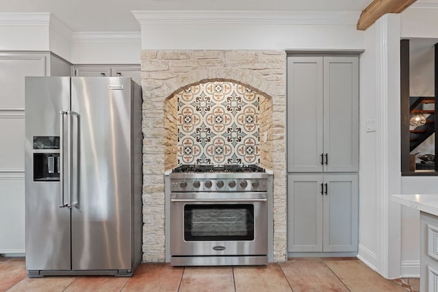 2906 Quail Run Dr, Round Rock, TX 78681 - kitchen with premium appliances, gray cabinetry, ornamental molding, light stone counters, and light tile patterned floors