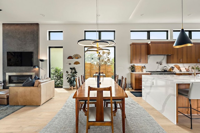2116 Kenwood Ave, Austin, TX 78704 - dining room featuring a high ceiling, light wood-style flooring, a fireplace, and recessed lighting