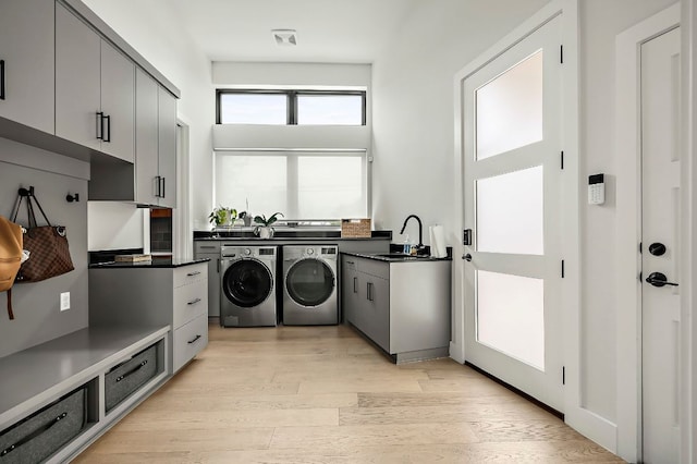 2116 Kenwood Ave, Austin, TX 78704 - laundry area featuring cabinet space, washing machine and clothes dryer, and light wood-style flooring
