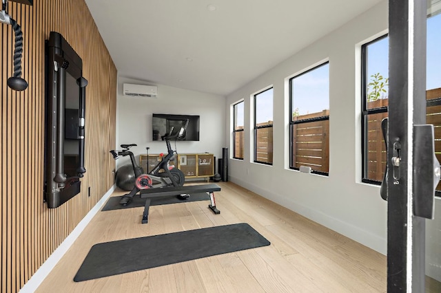 2116 Kenwood Ave, Austin, TX 78704 - workout room with wood finished floors, vaulted ceiling, a wall mounted AC, and baseboards