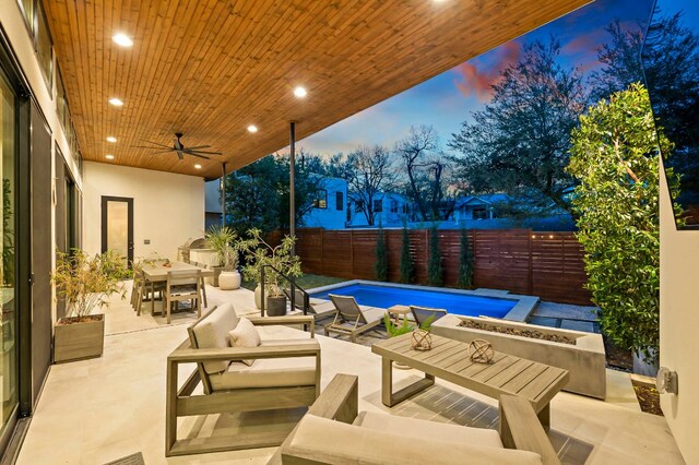 2116 Kenwood Ave, Austin, TX 78704 - patio terrace at dusk with an outdoor living space with a fire pit, a patio, outdoor dining area, and a fenced backyard