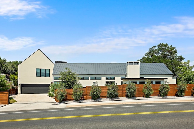 2116 Kenwood Ave, Austin, TX 78704 - view of front of home with a standing seam roof, an attached garage, metal roof, and driveway