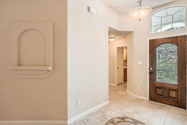 entrance foyer featuring baseboards and light tile patterned floors