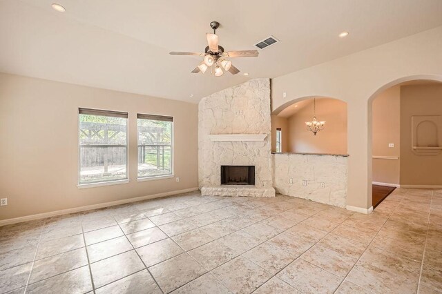 unfurnished living room with tile patterned floors, vaulted ceiling, ceiling fan with notable chandelier, visible vents, and arched walkways
