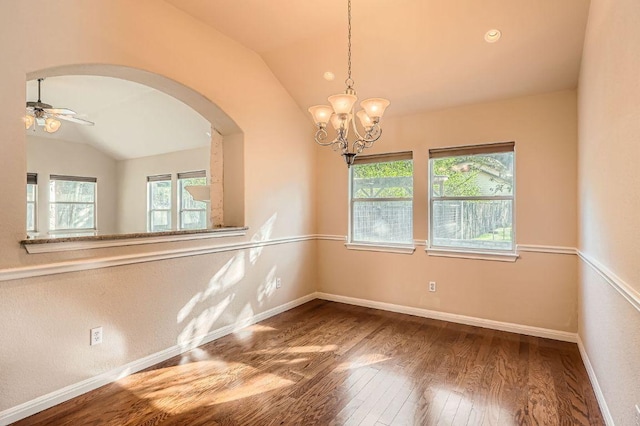 spare room featuring arched walkways, lofted ceiling, baseboards, and hardwood / wood-style flooring
