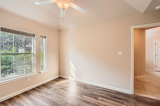 empty room with baseboards, ceiling fan, and wood finished floors