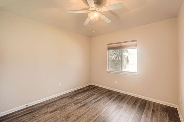 spare room with baseboards, ceiling fan, and dark wood-style flooring