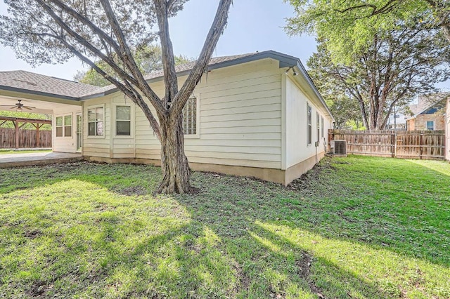 view of home's exterior with central air condition unit, ceiling fan, a fenced backyard, a lawn, and a patio area