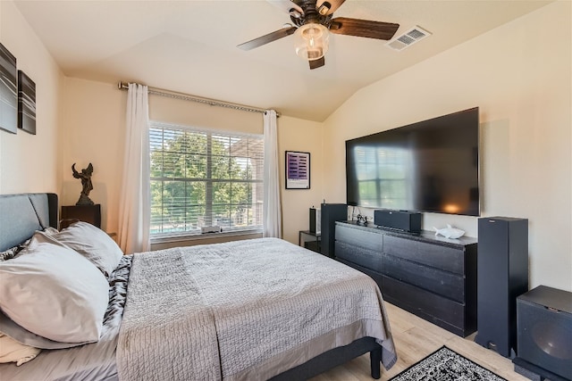 bedroom with light wood-style floors, a ceiling fan, lofted ceiling, and visible vents