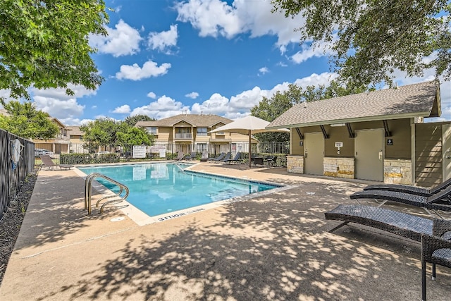 pool with a patio and fence
