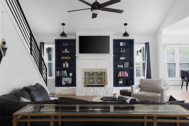 6307 Cannonleague Dr, Austin, TX 78745 - living room with lofted ceiling, ceiling fan, stairway, a fireplace with raised hearth, and wood finished floors