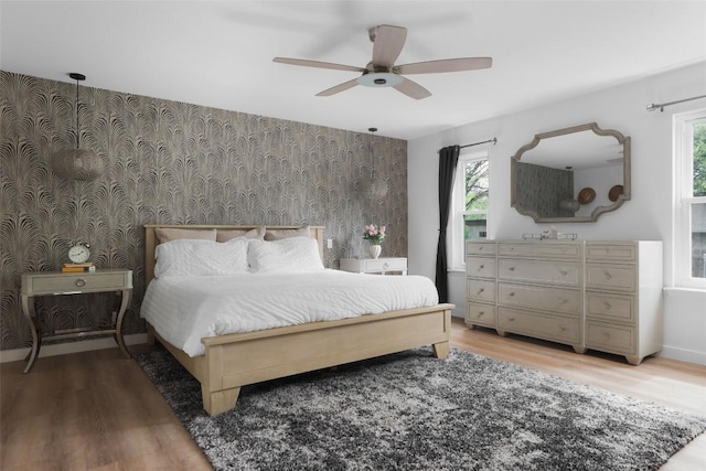 6307 Cannonleague Dr, Austin, TX 78745 - bedroom with an accent wall, light wood-style flooring, wallpapered walls, and ceiling fan