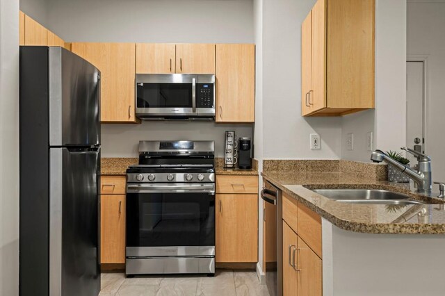 2209 Hancock Dr Unit 3, Austin, TX 78756 - kitchen featuring appliances with stainless steel finishes, dark stone countertops, and light brown cabinetry