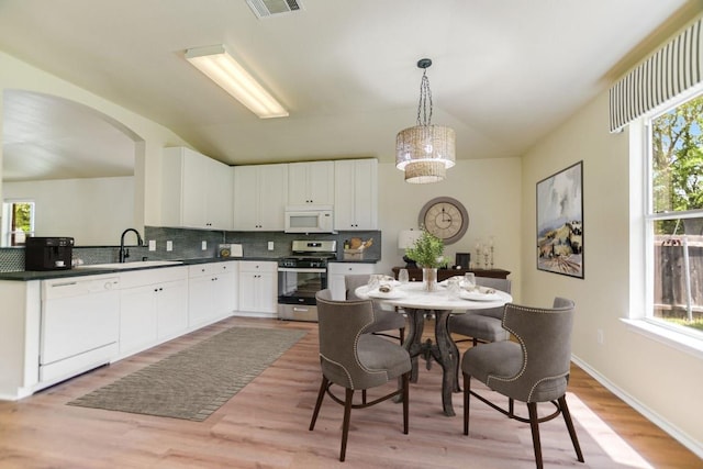 402 Washington Square Dr, Leander, TX 78641 - kitchen featuring white appliances, a sink, vaulted ceiling, decorative backsplash, and plenty of natural light