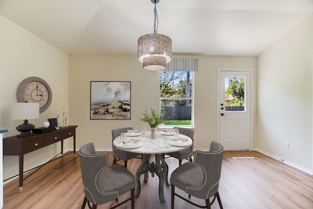 402 Washington Square Dr, Leander, TX 78641 - dining area with light wood finished floors, a chandelier, and baseboards