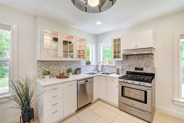 3902 Willbert Rd, Austin, TX 78751 - kitchen featuring appliances with stainless steel finishes, a sink, under cabinet range hood, light countertops, and decorative backsplash