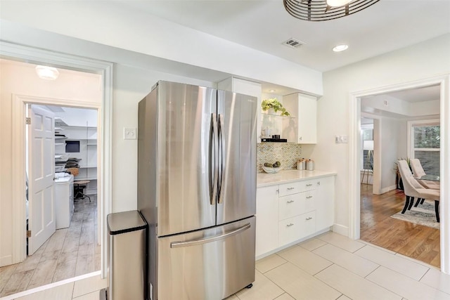 3902 Willbert Rd, Austin, TX 78751 - kitchen featuring freestanding refrigerator, white cabinets, light countertops, tasteful backsplash, and light tile patterned floors