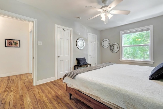 3902 Willbert Rd, Austin, TX 78751 - bedroom with light wood finished floors, baseboards, a ceiling fan, and multiple closets
