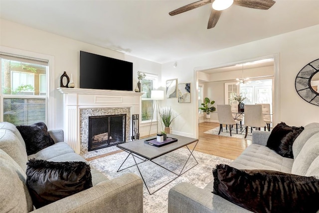 3902 Willbert Rd, Austin, TX 78751 - living room featuring ceiling fan, wood finished floors, a fireplace, baseboards, and a chandelier