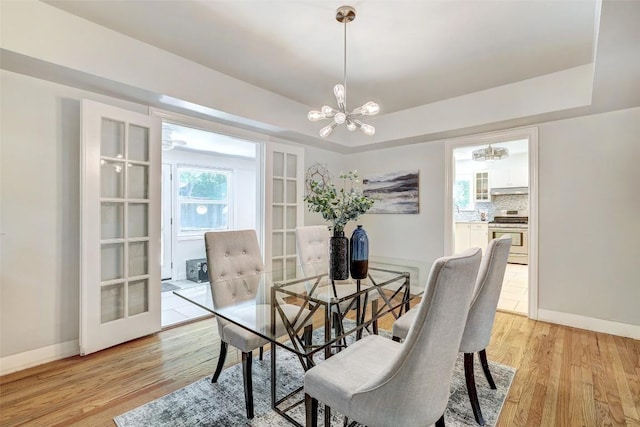 3902 Willbert Rd, Austin, TX 78751 - dining space featuring a chandelier, light wood-style floors, and a raised ceiling