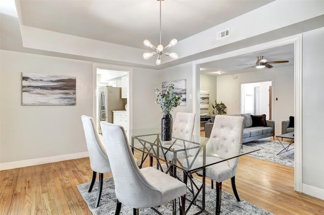 3902 Willbert Rd, Austin, TX 78751 - dining area with light wood finished floors, a chandelier, baseboards, a tray ceiling, and a ceiling fan