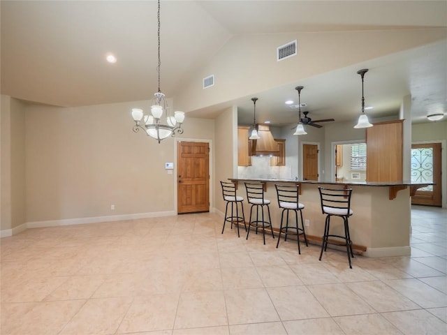 1008 Laurel Oak Cir, Marble Falls, TX 78654 - kitchen with a kitchen breakfast bar, light tile patterned floors, a peninsula, pendant lighting, and high vaulted ceiling