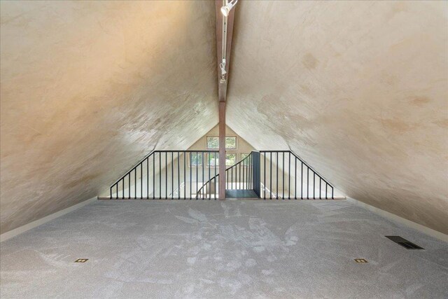additional living space featuring carpet, vaulted ceiling, and visible vents