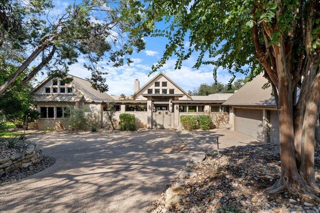 craftsman-style home with a chimney, an attached garage, a gate, and concrete driveway