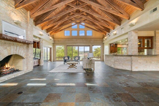 interior space with stone tile flooring, visible vents, beamed ceiling, high vaulted ceiling, and wooden ceiling
