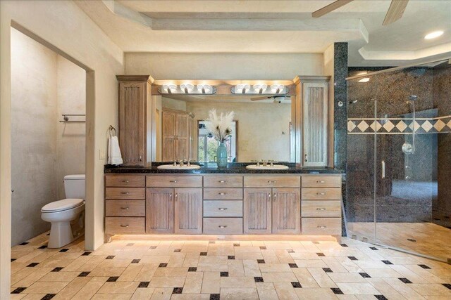 bathroom featuring a sink, toilet, double vanity, and a stall shower