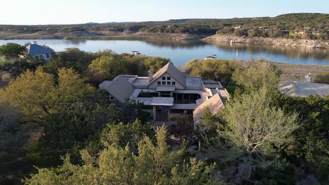 birds eye view of property with a view of trees and a water view