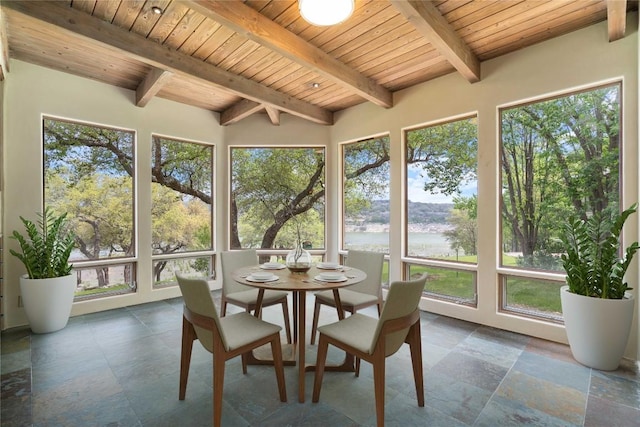 sunroom with beamed ceiling, stone tile floors, and wood ceiling
